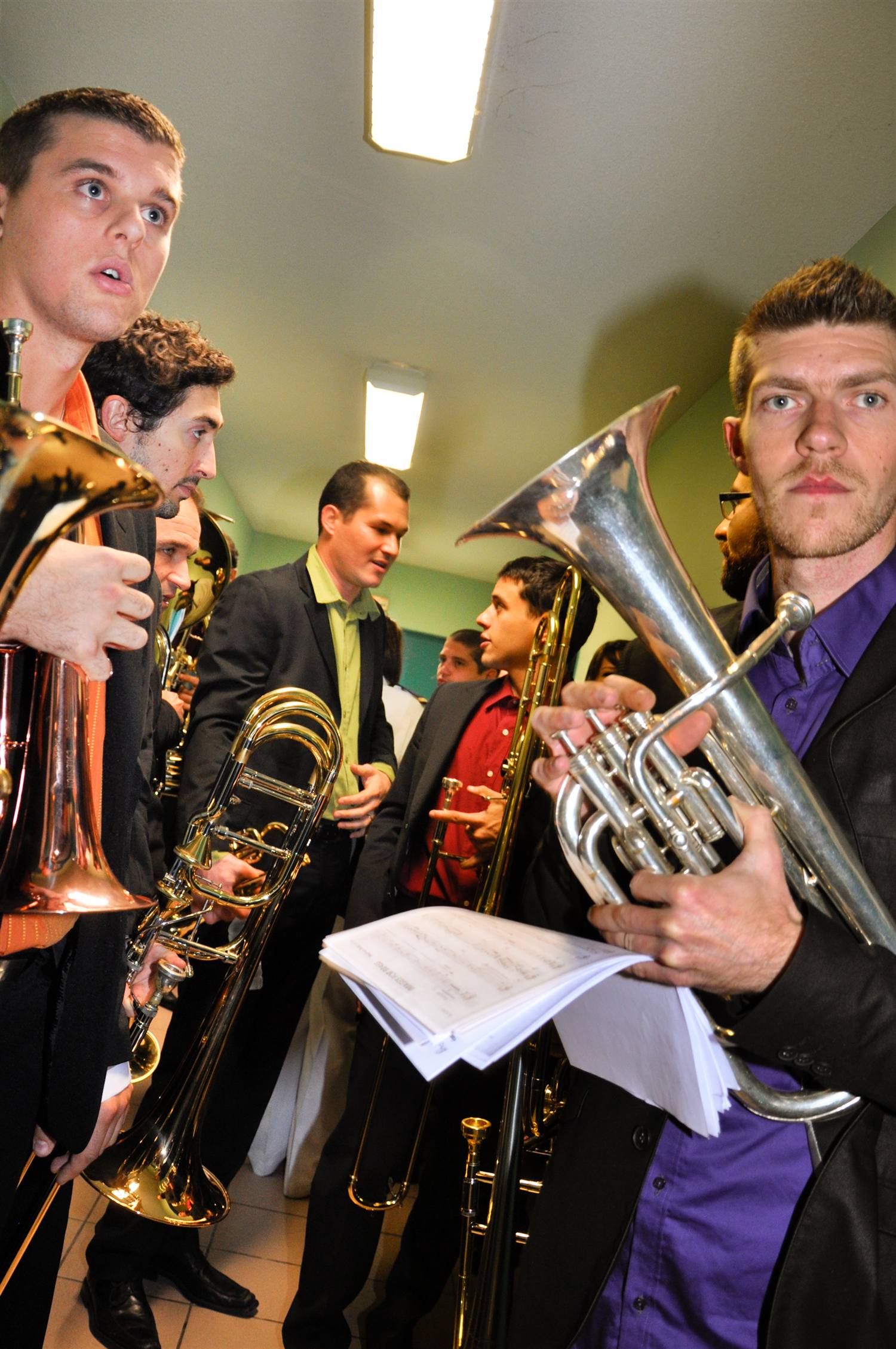 Des musiciens et leurs instruments dans un couloir, en coulisses.