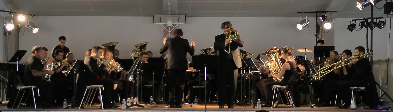 Un tromboniste soliste debout, jouant avec le Brass Band Occitania à L'Isle-Jourdain.